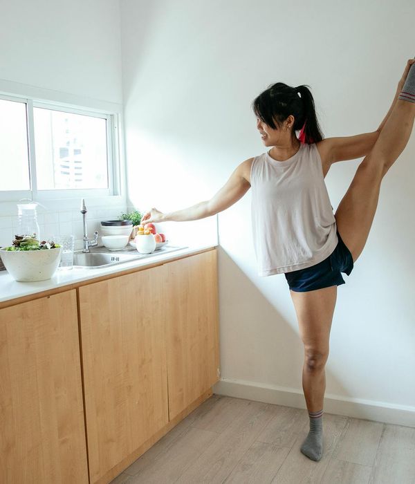 Woman practicing a peaceful morning stretch by a window.